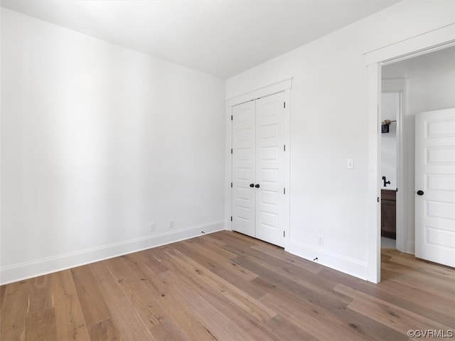 unfurnished bedroom featuring wood-type flooring and a closet