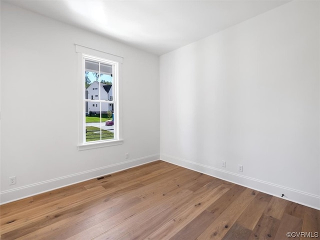 unfurnished room with hardwood / wood-style flooring