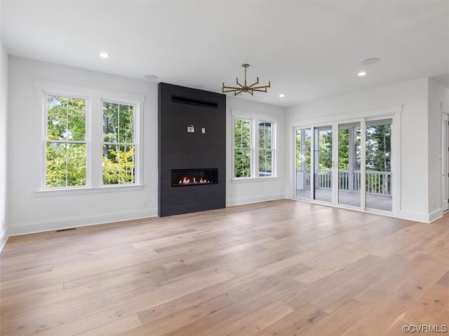 unfurnished living room with light hardwood / wood-style floors, a healthy amount of sunlight, and a fireplace