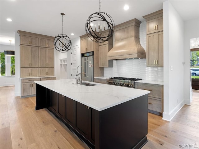 kitchen with a spacious island, custom exhaust hood, light wood-type flooring, and sink