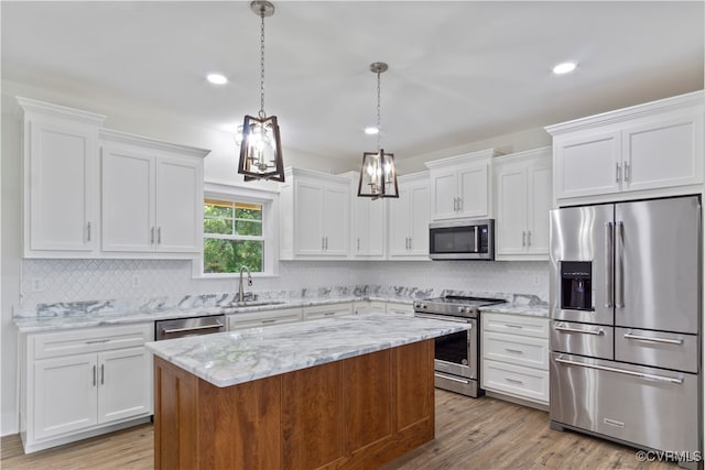 kitchen with light hardwood / wood-style floors, a center island, sink, white cabinetry, and stainless steel appliances