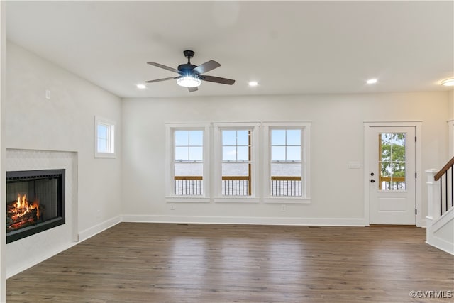 unfurnished living room featuring dark hardwood / wood-style floors and ceiling fan