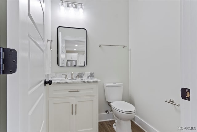 bathroom with hardwood / wood-style flooring, vanity, and toilet