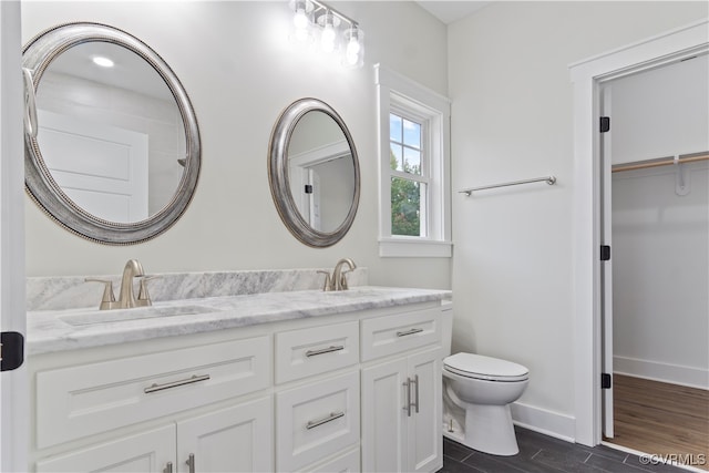 bathroom with wood-type flooring, vanity, and toilet