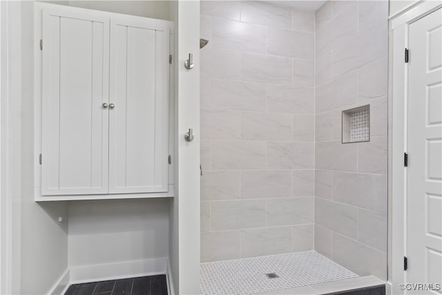 bathroom featuring hardwood / wood-style floors and a tile shower