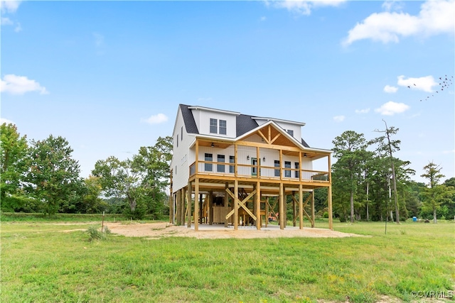 rear view of property with a balcony, a yard, and a patio area