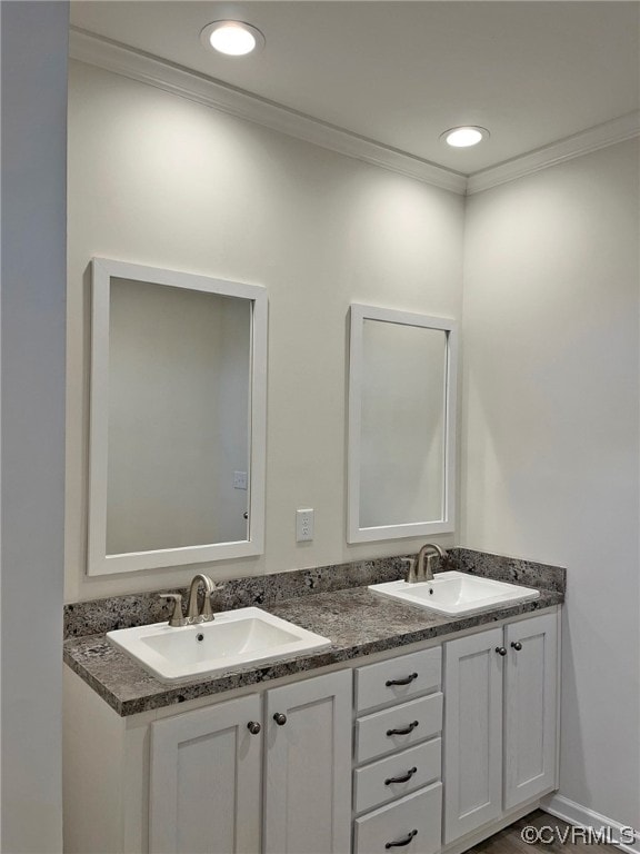 bathroom featuring a sink, recessed lighting, ornamental molding, and double vanity