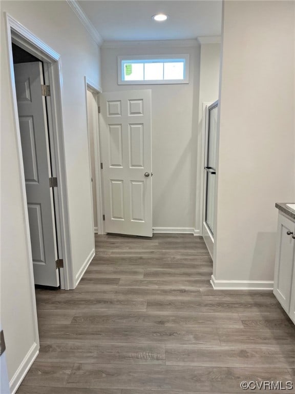 interior space with crown molding, light wood-style flooring, and baseboards