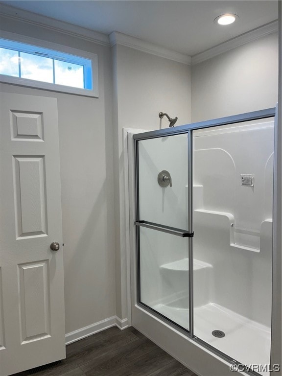 full bath featuring baseboards, a shower stall, wood finished floors, and crown molding