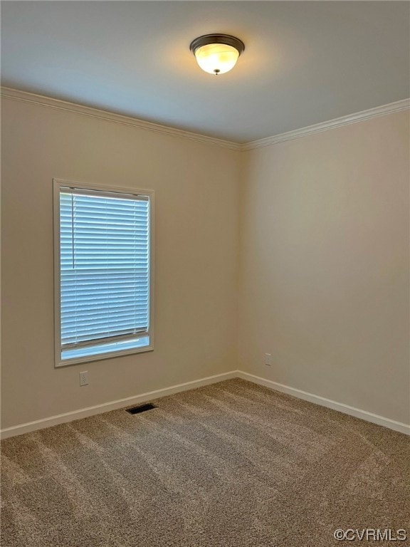 carpeted empty room featuring visible vents, crown molding, and baseboards