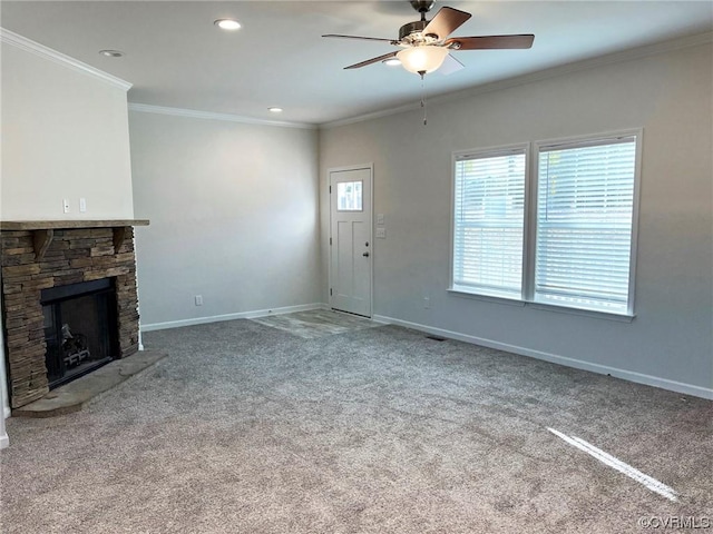 unfurnished living room with a ceiling fan, baseboards, a fireplace, ornamental molding, and carpet flooring