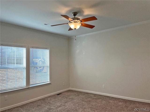 empty room with visible vents, crown molding, baseboards, carpet floors, and a ceiling fan