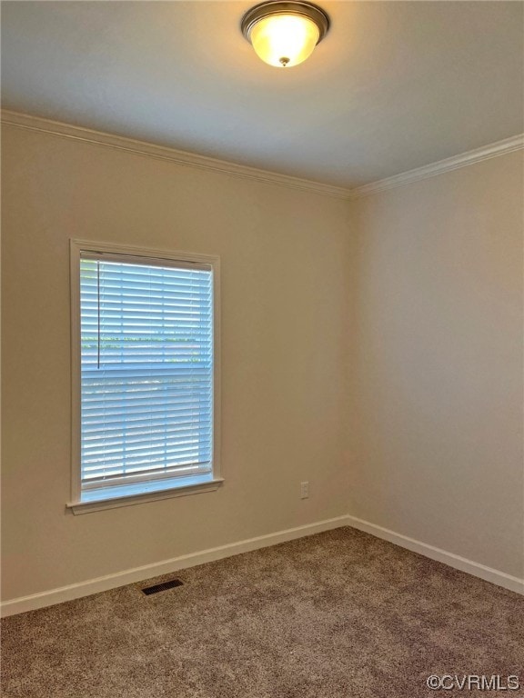 carpeted spare room with crown molding, baseboards, and visible vents