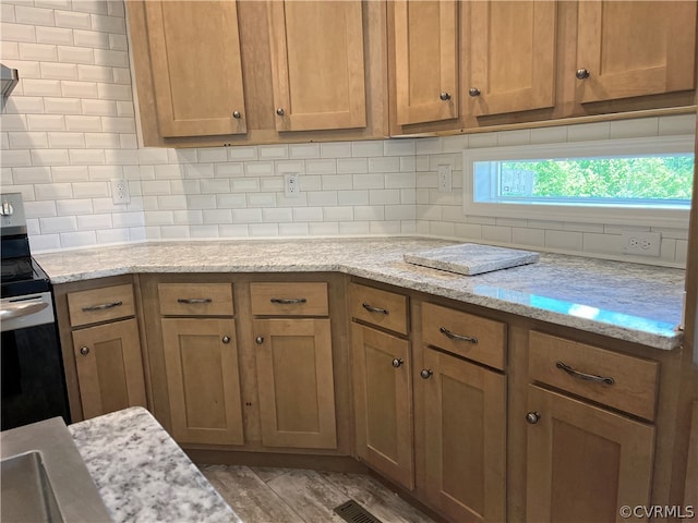 kitchen featuring tasteful backsplash, stainless steel electric stove, and light stone counters