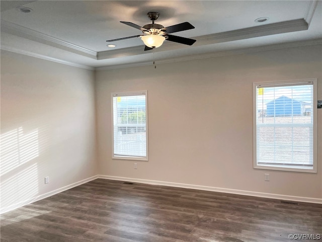 unfurnished room featuring crown molding, baseboards, dark wood finished floors, a tray ceiling, and a ceiling fan