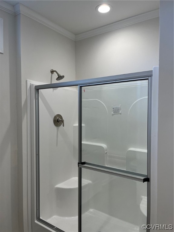 bathroom with crown molding and a stall shower