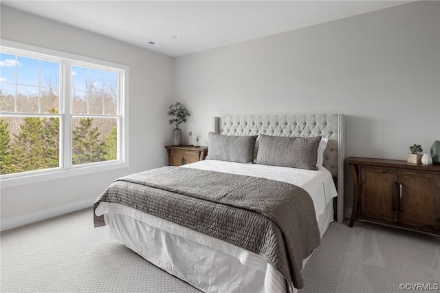 bedroom featuring light carpet and multiple windows