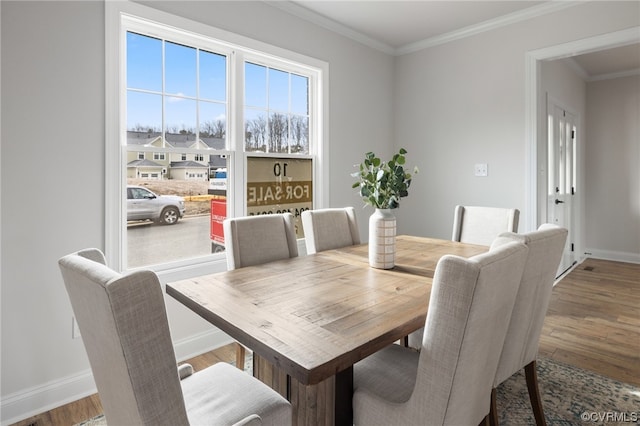 dining space featuring hardwood / wood-style flooring and crown molding