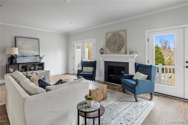 living room featuring french doors, ornamental molding, a healthy amount of sunlight, and hardwood / wood-style flooring