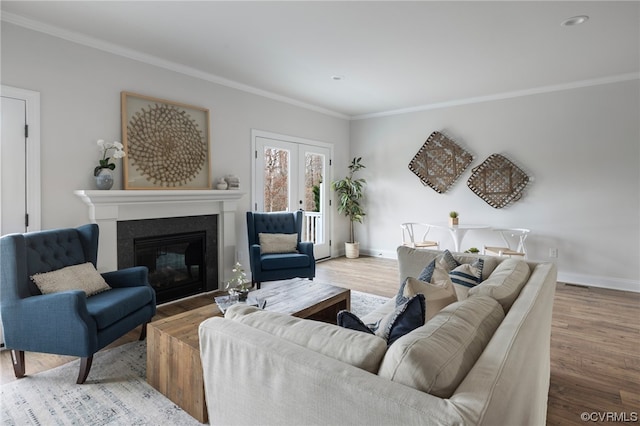 living room with crown molding, wood-type flooring, and french doors