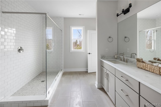 bathroom with tile floors, an enclosed shower, and vanity