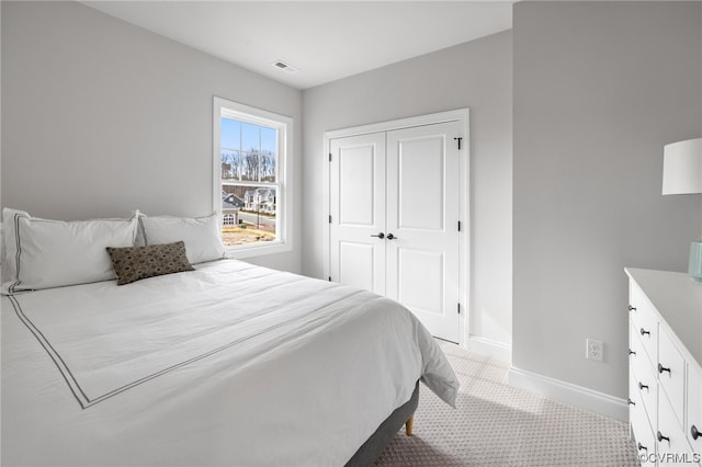 bedroom featuring light colored carpet and a closet