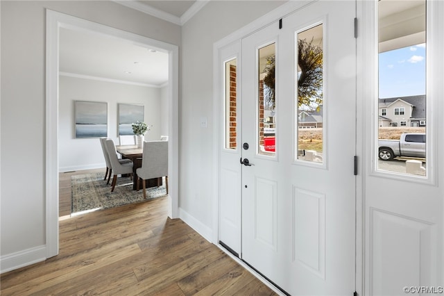 entryway with dark hardwood / wood-style flooring, ornamental molding, and a wealth of natural light