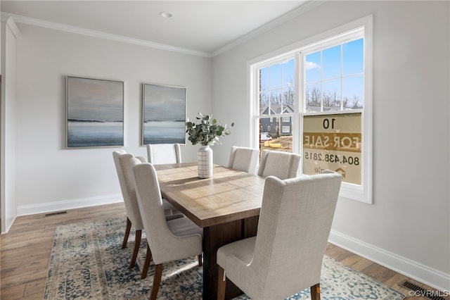 dining space featuring ornamental molding and hardwood / wood-style floors