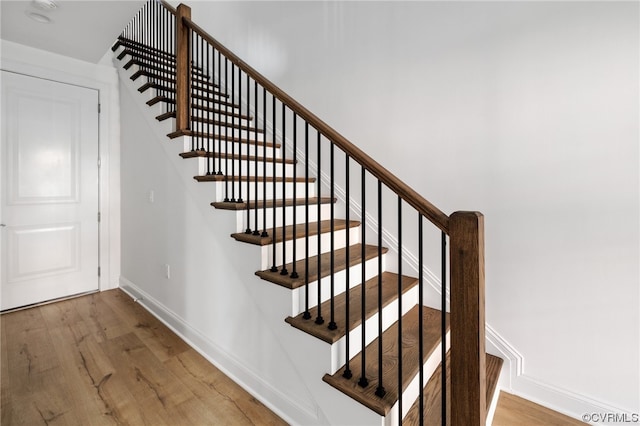 stairway with light hardwood / wood-style floors