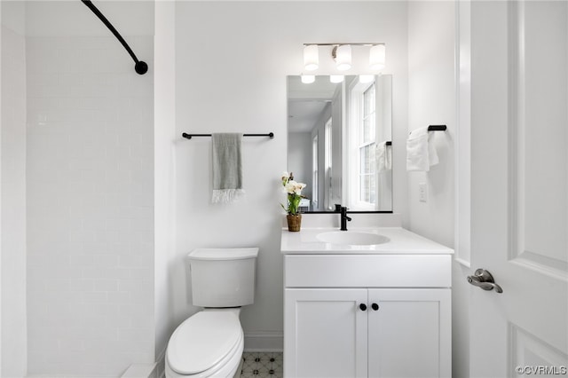 bathroom featuring a shower, toilet, large vanity, and tile floors