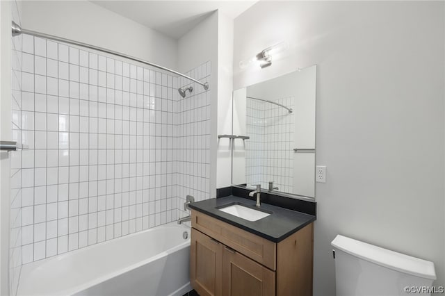 full bathroom featuring toilet, vanity, and tiled shower / bath