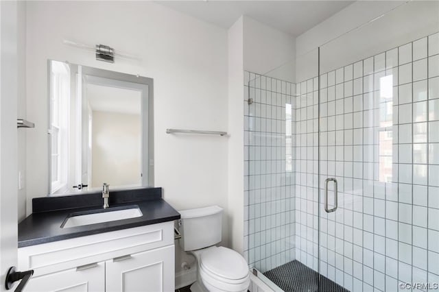 bathroom with an enclosed shower, vanity, and toilet