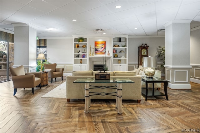 living room featuring dark parquet flooring, built in shelves, and crown molding