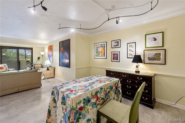 bedroom with rail lighting, a textured ceiling, and crown molding