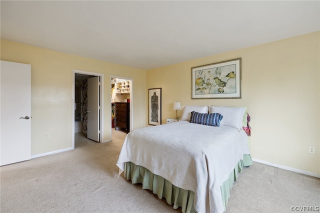 carpeted bedroom featuring a closet and a walk in closet