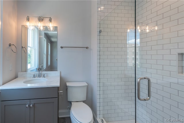 bathroom with a shower with shower door, toilet, and vanity