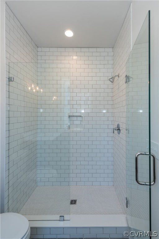 bathroom featuring walk in shower and toilet