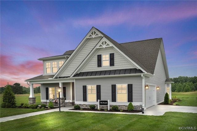 craftsman-style house featuring a porch, a yard, and a garage