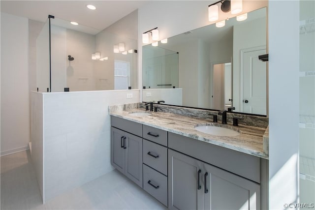 bathroom with tile patterned flooring, vanity, and walk in shower