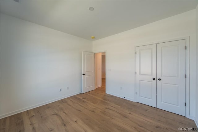 unfurnished bedroom featuring a closet and light wood-type flooring