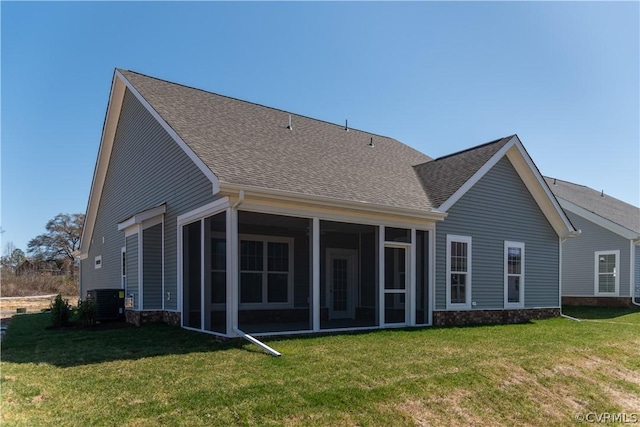 rear view of property with a yard, central air condition unit, and a sunroom