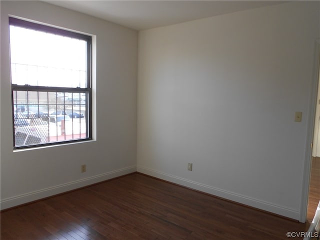 unfurnished room with dark hardwood / wood-style flooring