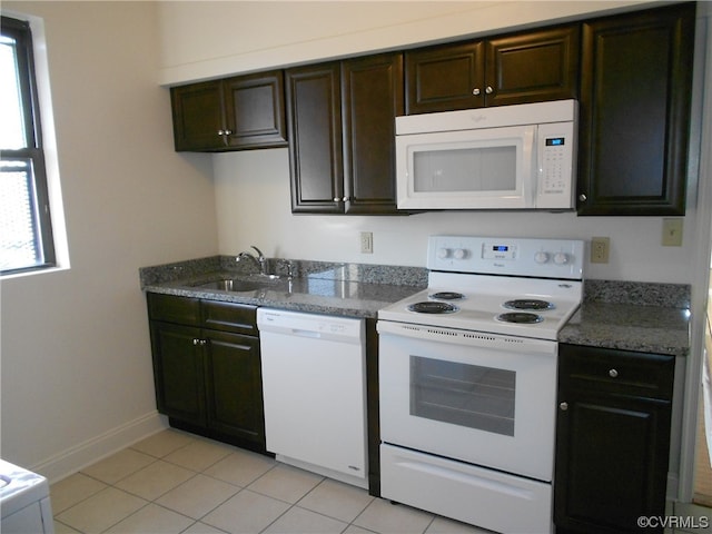 kitchen featuring light tile floors, white appliances, dark brown cabinets, and sink