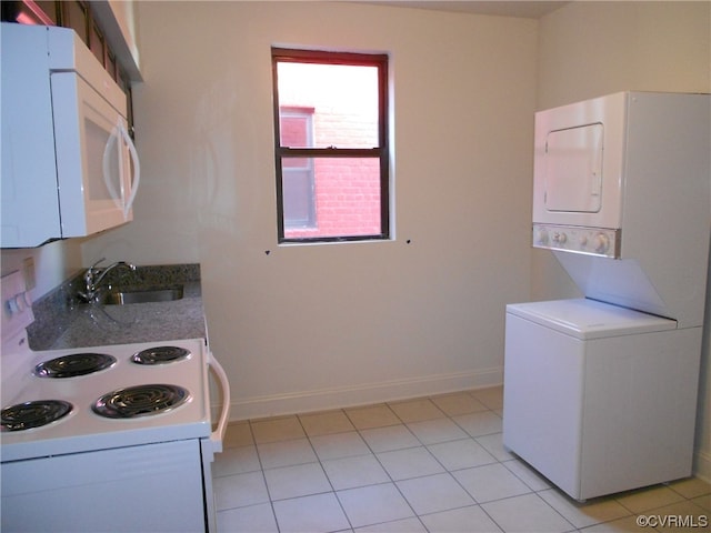 kitchen featuring white appliances, white cabinetry, light tile floors, and stacked washing maching and dryer