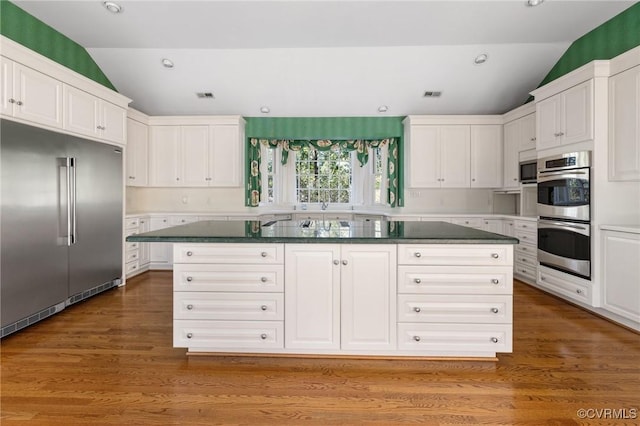 kitchen featuring stainless steel appliances, white cabinetry, and a center island