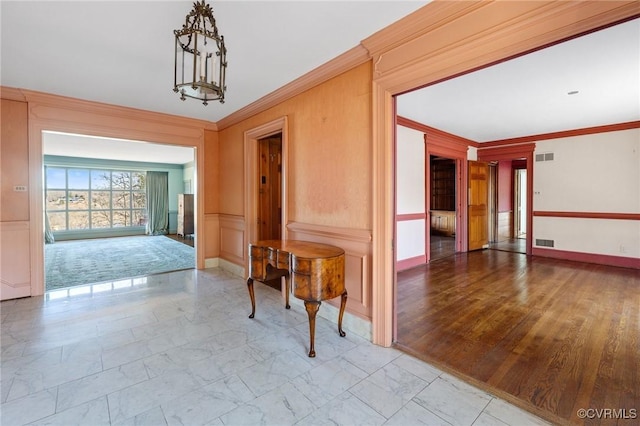 hall featuring ornamental molding and a notable chandelier