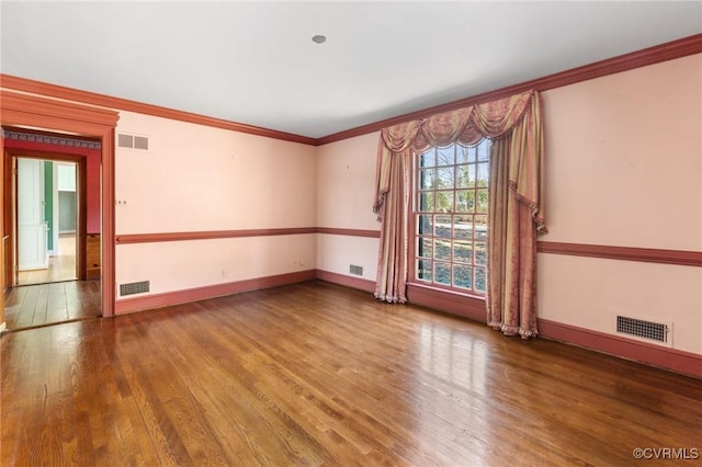 spare room featuring crown molding and hardwood / wood-style floors