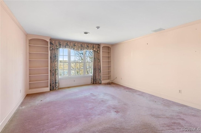 carpeted empty room with ornamental molding and built in shelves