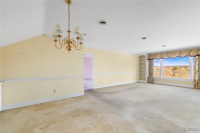 empty room featuring a chandelier and carpet