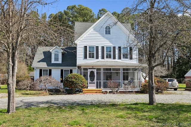 view of front of home featuring a sunroom and a front yard